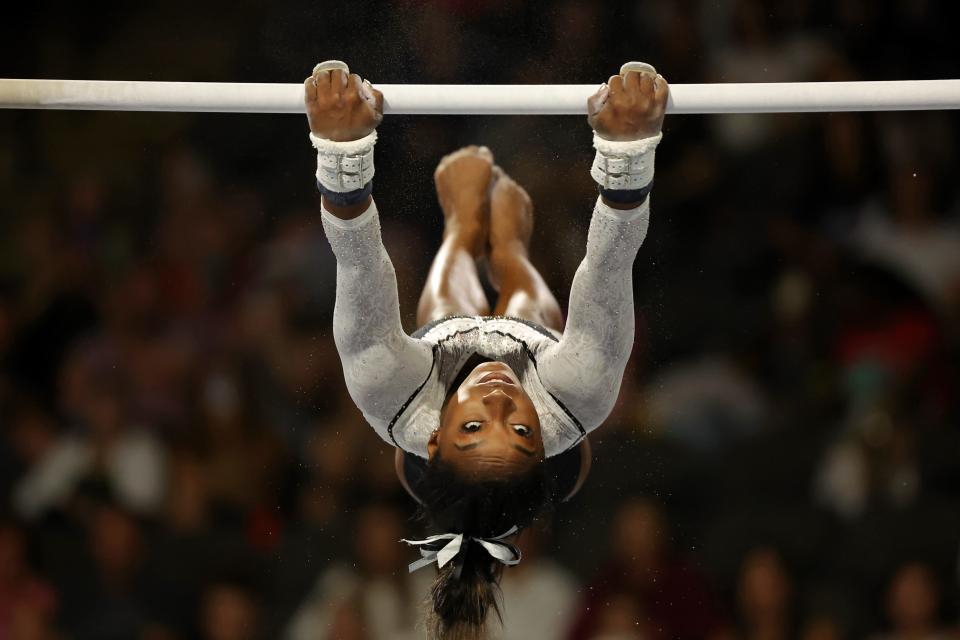 Simone Biles performs on the uneven bars.