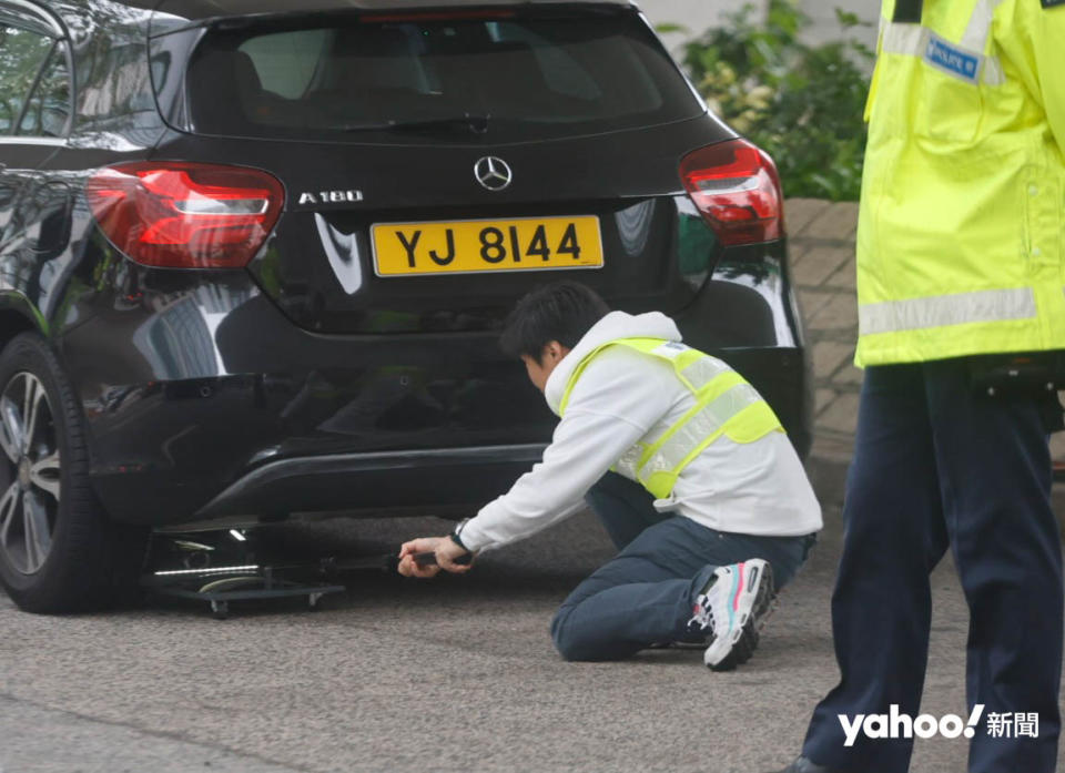 警方在法院外利用金屬探測器及警犬檢查一輛私家車及車底。