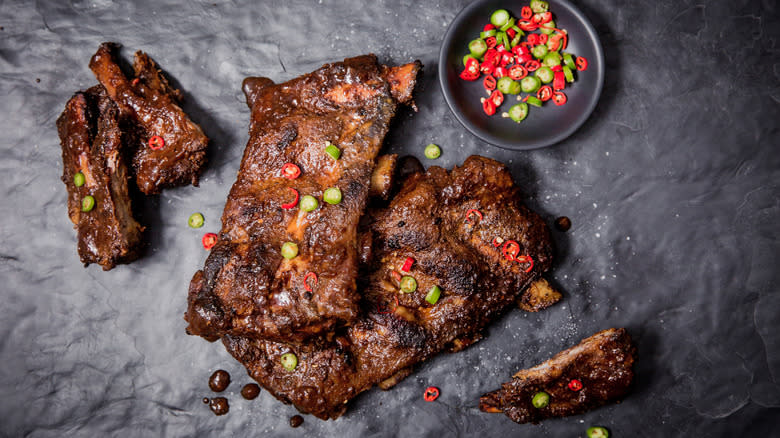 Meat beside bowl of chilis