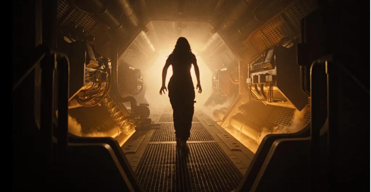  A woman stands in silhouette in a spooky spaceship corridor. 