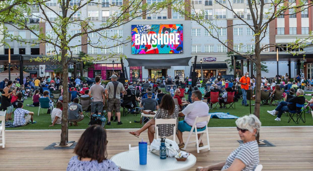 A crowd gathers in Bayshore Mall's new public square, known as The Yard at Bayshore, for the Sounds of Summer concert series July 10, 2020. Malls still serve as a place to gather.