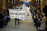 <p>Habitués à accueillir des mannequins, les podiums de la Fashion Week se transforment parfois en tribunes où viennent s’exprimer les défenseurs de diverses causes. Lors du défilé Louis Vuitton, qui s’est tenu au Louvre, une militante d’Extinction Rebellion, un mouvement international qui lutte et alerte contre le dérèglement climatique, a fait irruption sur le catwalk avec une banderole « Overconsumption = extinction » (surconsommation = extinction). La jeune femme, qui a attiré tous les regards et dont le message est devenu la star du show, a été rapidement saisie par un membre de la sécurité. ©Getty Images</p> 