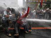 Police train their fire hose at protesters as the latter try to force their way closer to the U.S. Embassy for a rally against next week's visit of U.S. President Barack Obama Wednesday, April 23, 2014 in Manila, Philippines. Philippine police armed with truncheon, shields and water hose have clashed with more than 100 left-wing activists who rallied at the U.S. Embassy in Manila to oppose a visit by Obama and a looming pact that will increase the American military presence in the Philippines. (AP Photo/Bullit Marquez)