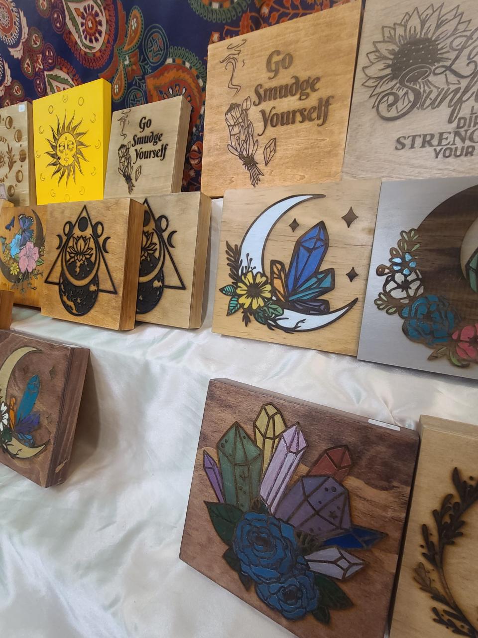 A variety of colorful signs, displaying images crystal, flowers, celestial objects and more, are for sale at Sirona Natural Healing Shop in downtown Clyde.