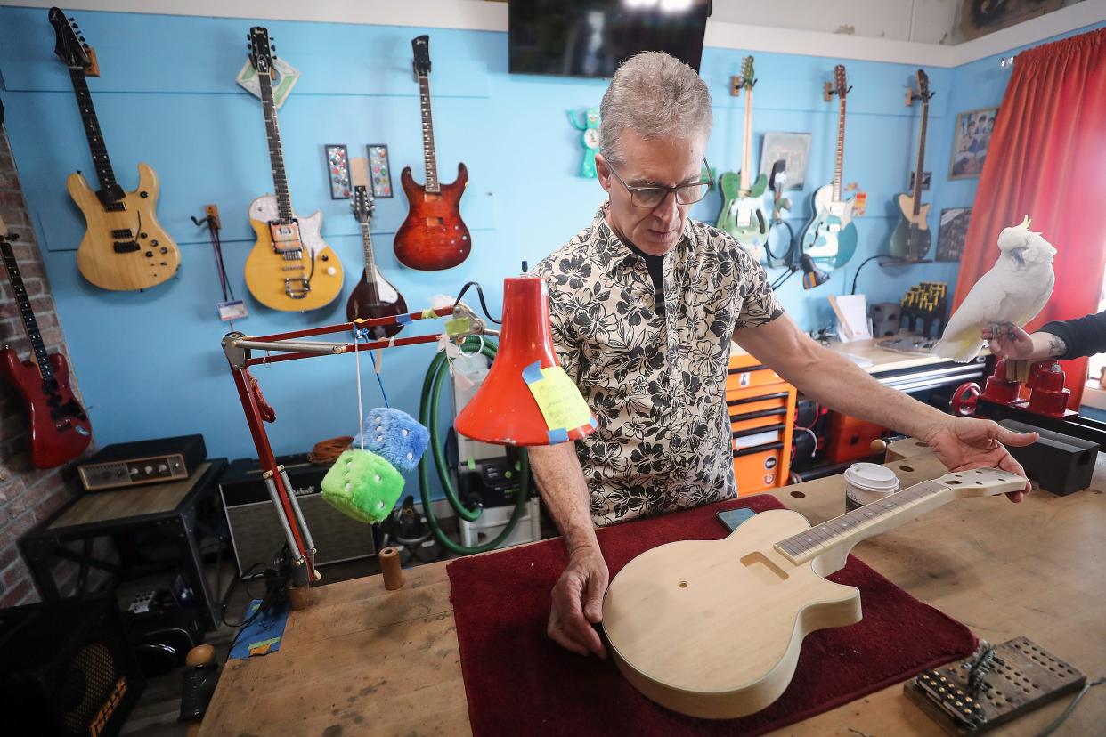 TV Jones founder and president Thomas V. Jones looks over a wooden mandolin that they are making on Thursday, April 11, 2024.