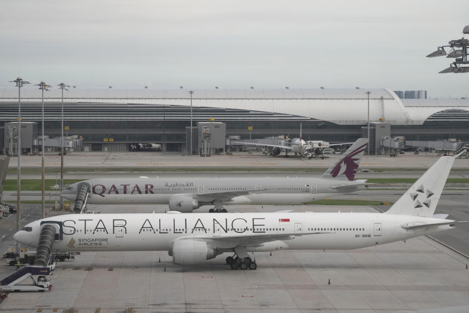 The Boeing 777-300ER aircraft of Singapore Airlines, front, is parked after the SQ321 London-Singapore flight, that encountered severe turbulence, at Suvarnabhumi International Airport, near Bangkok, Thailand, Wednesday, May 22, 2024. The Singapore Airlines flight descended 6,000 feet (around 1,800 meters) in about three minutes, the carrier said Tuesday. A British man died and authorities said dozens of passengers were injured, some severely. (AP Photo/Sakchai Lalit)