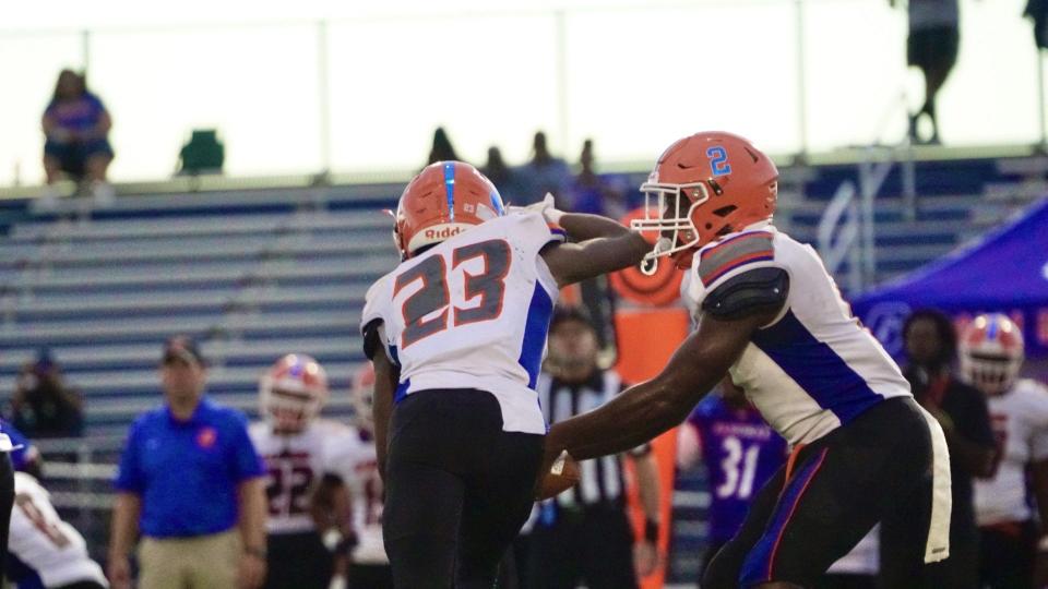 Palm Beach Gardens quarterback Keyon Stephens (right) fakes a handoff to Wilfred Coicou (23) in a game at Pahokee on Sept. 21, 2023.