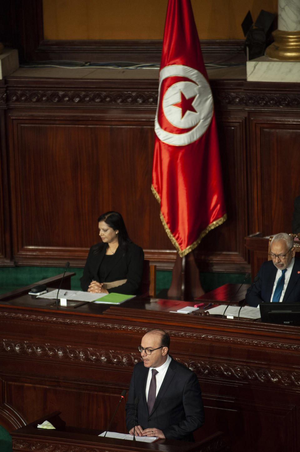 Tunisian designated Prime Minister Elyes Fakhfakh, below center, delivers his speech at the parliament, Wednesday, Feb. 26, 2020. Tunisia's parliament is expected to hold a confidence vote Wednesday on designated prime minister Elyes Fakhfakh's government. (AP Photo/Hassene Dridi)
