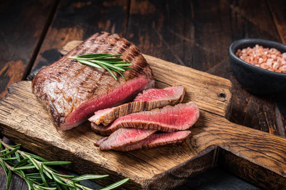 barbecue dry aged wagyu flank steak on a cutting board wooden background top view