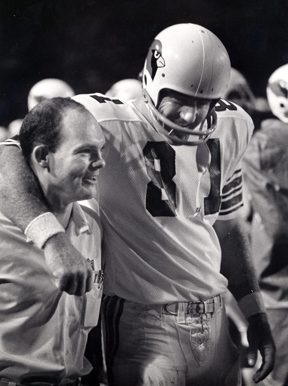 Longtime Cardinals trainer John Omohundro is seen with tight end Jackie Smith.