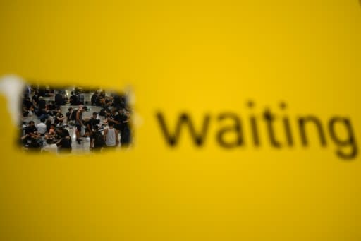 Pro-democracy protesters wait in the arrivals hall of Hong Kong's international airport during a protest which led to the cancellation of at least 150 flights