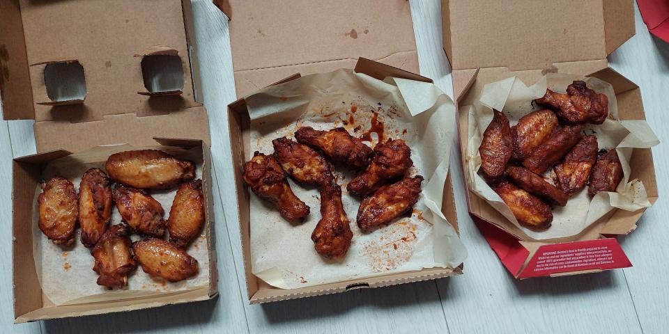 Boxes of chicken from Pizza Hut, Domino's, and Papa John's