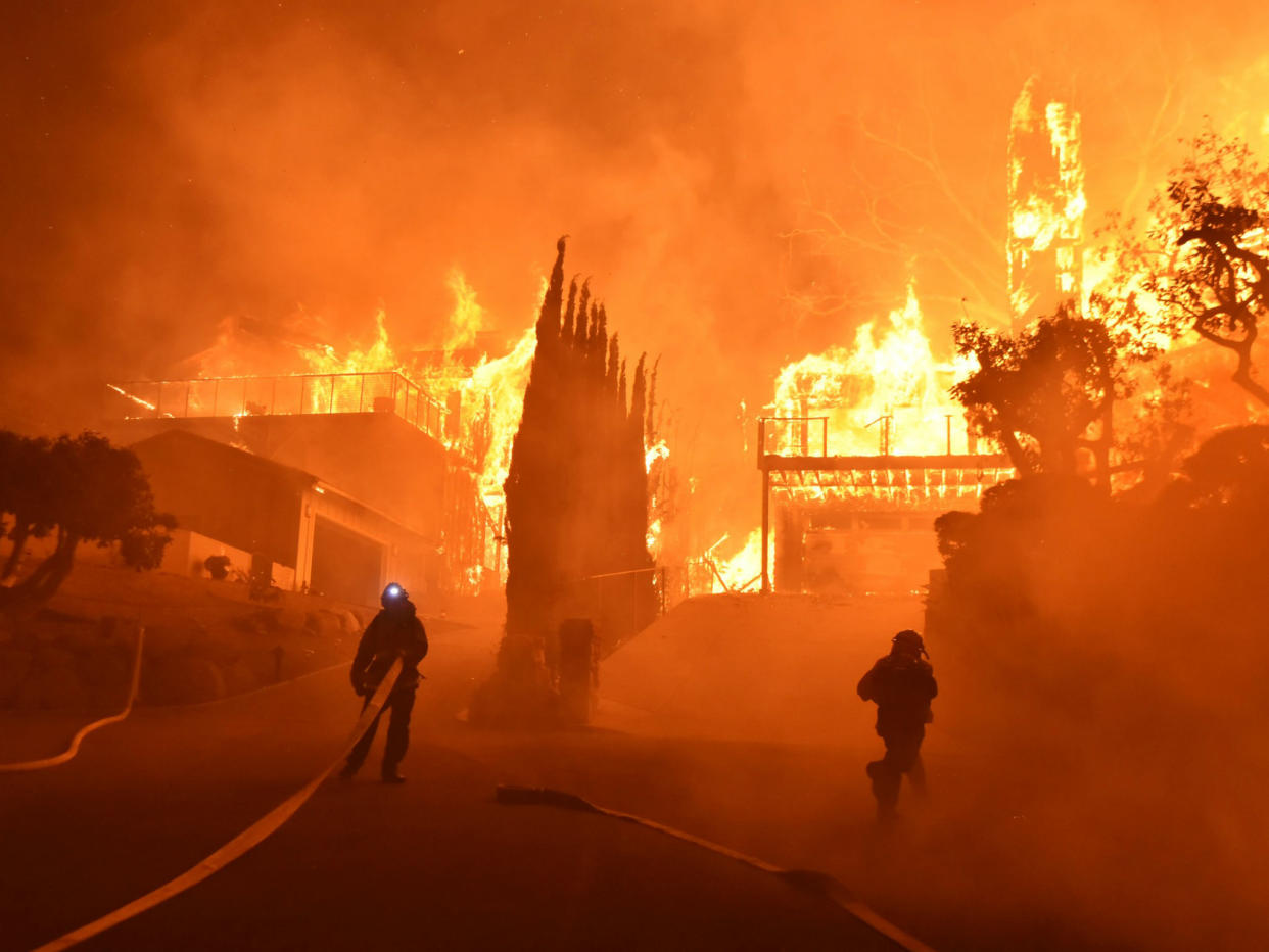 Firefighters work to put out a blaze burning homes in Ventura, California: Ryan Cullom/Ventura County Fire Department via AP