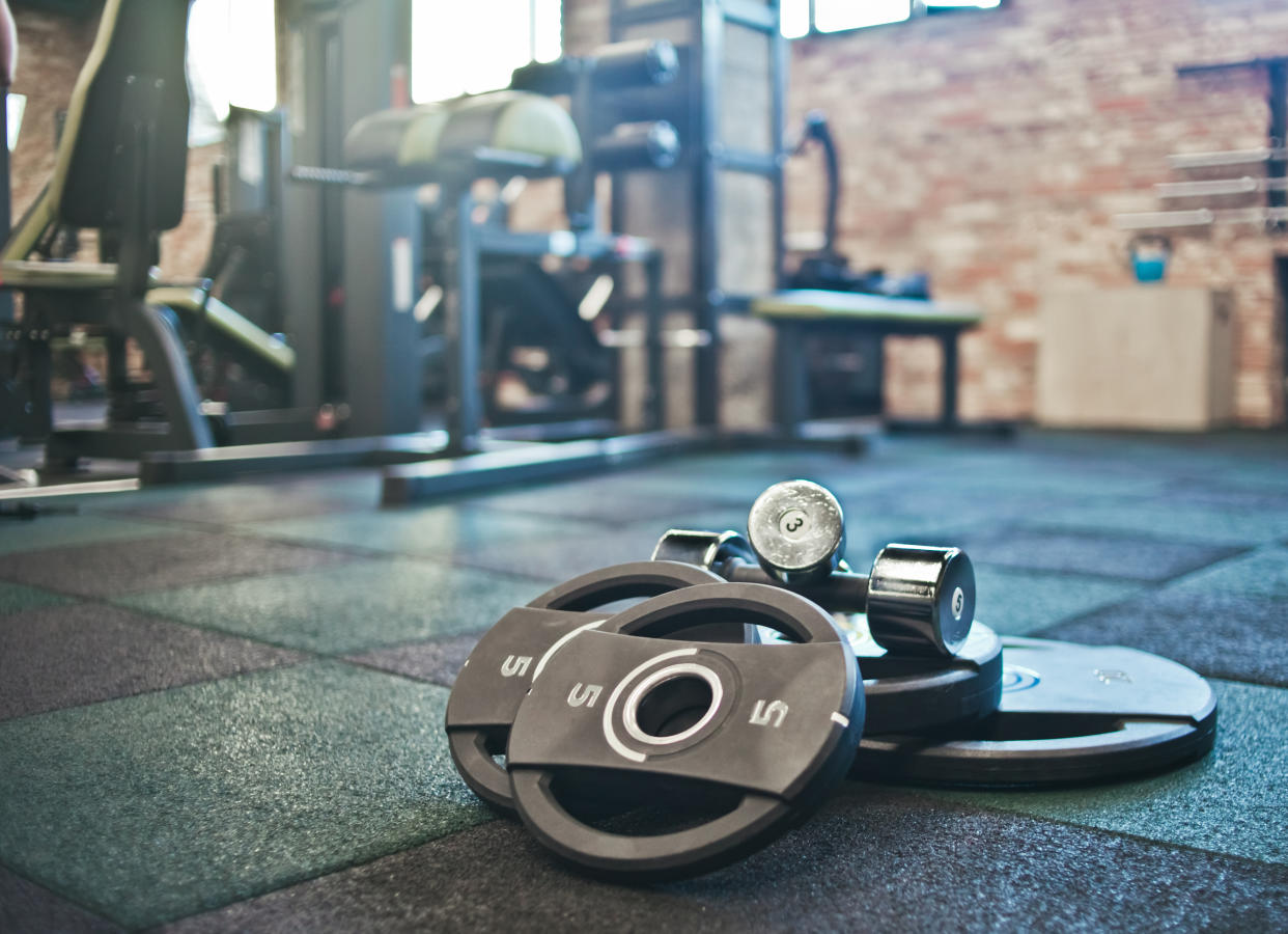 Barbell, dumbbells lie on the floor against the background of the gym. (Getty Images)