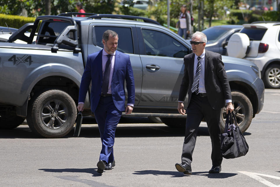 Lawyer Paulo Cunha, left, accompanied by adviser Osmar Crivelatti, arrives to return weapons received by Brazil's former President Jair Bolsonaro at the Federal Police headquarters in Brasilia, Brazil, Friday, March 24, 2023. Representatives of Bolsonaro on Friday returned weapons he received from the United Arab Emirates and a set of jewels from Saudi Arabia, both of which he received during his presidency, as he was ordered to do by a Brazilian government watchdog. (AP Photo/Eraldo Peres)