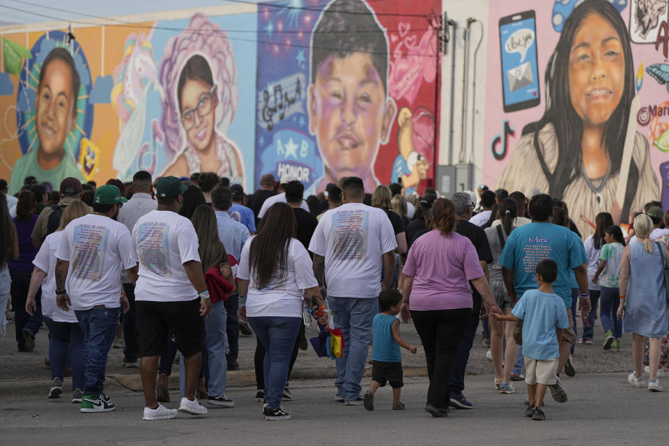 Family member make a mural walk before a candlelight vigil in Uvalde, Texas, Wednesday, May 24, 2023. One year ago a gunman killed 19 children and two teachers inside a fourth-grade classroom. (AP Photo/Eric Gay)
