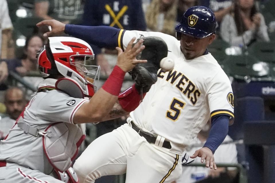 Milwaukee Brewers' Eduardo Escobar scores safely past Philadelphia Phillies catcher Rafael Marchan during the third inning of a baseball game Tuesday, Sept. 7, 2021, in Milwaukee. Escobar scored from second on a hit by Christian Yelich. (AP Photo/Morry Gash)