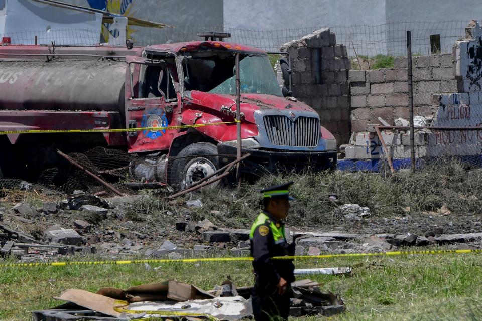 <p>Police officers stand guard at the site after a series of explosions at fireworks warehouses in Tultepec, central Mexico, on July 5, 2018. – At least 17 people were killed, including rescue workers who died saving others’ lives, officials said. The initial explosion occurred around 9:30 am (1430 GMT), then spread to other warehouses just as police and firefighters began attending to the first victims. (Photo: Pedro Pardo/AFP/Getty Images) </p>