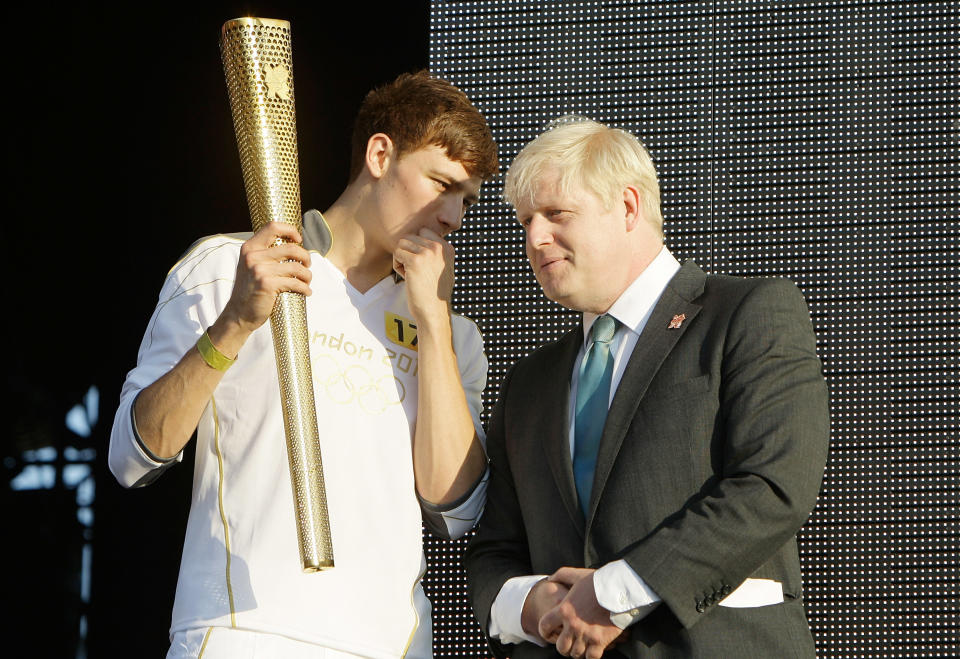 Tyler Rix and Mayor Boris Johnson with the Olympic Torch at Coca-Cola's London 2012 Olympic Torch Relay Concert at Hyde Park in London.