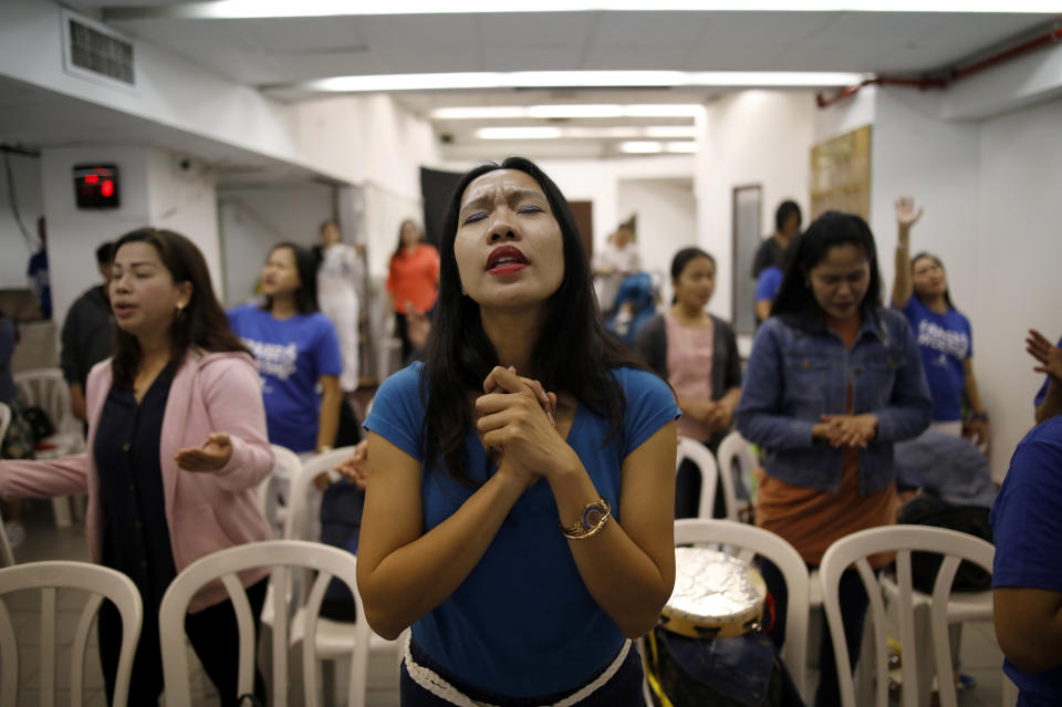 Merry Christ Palacios, a caregiver from the Philippines, during a church service held at the Central Bus Station on April 13. Palacios shops at the station and worships in its church. (Photo: Corinna Kern/Reuters)