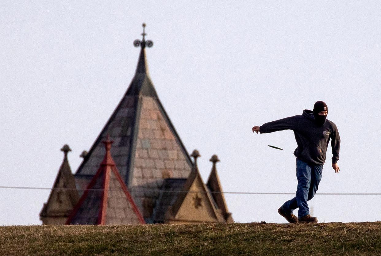 Gavin Anderson, of Chillicothe, practices throwing his disc golf discs from atop the flood wall to the disc golf goal at Yochtangee Park Annex on Feb. 2, 2023 in Chillicothe, Ohio.