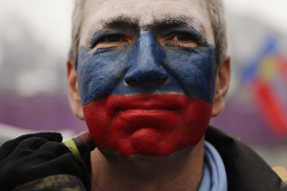 Kamil Aizetulin gets his face painted in the colors of the Russian flag during a women's ski cross seeding run at the Rosa Khutor Extreme Park, during the 2014 Winter Olympics, Feb. 21, 2014, in Krasnaya Polyana, Russia. 