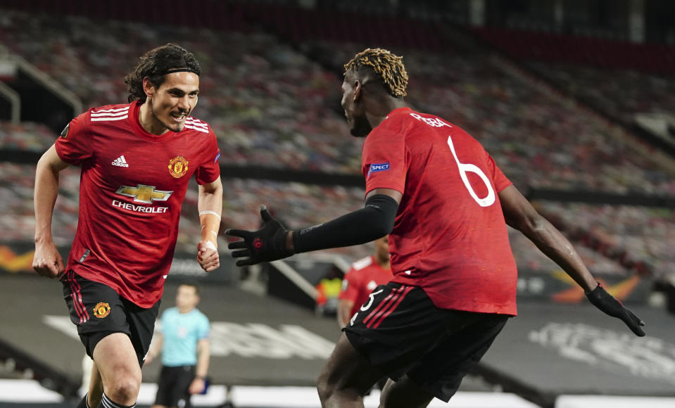 Edinson Cavani (izquierda) celebra con Paul Pogba tras anotar el tercer gol del Manchested United en la victoria 6-2 ante la Roma por las semifinales de la Liga Europa, el jueves 29 de abril de 2021. (AP Foto/Jon Super)