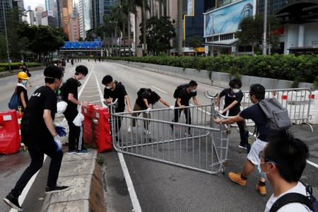 Protesters move barricades as they block one of the main streets during a demonstration demanding Hong Kong's leaders to step down and withdraw the extradition bill, in Hong Kong
