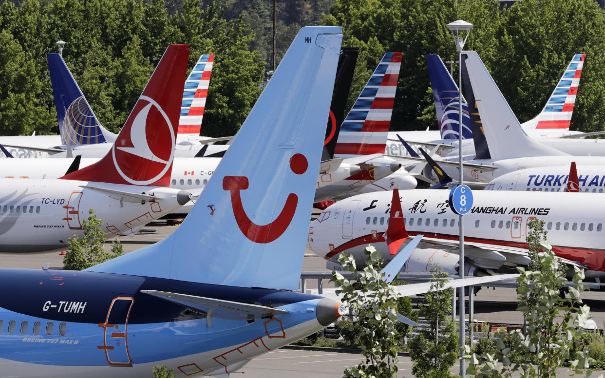 Dozens of grounded Boeing 737 MAX airplanes, including one for TUI Airlines, center, crowd a parking area adjacent to Boeing Field Thursday, Aug. 15, 2019, in Seattle. Aviation authorities around the world grounded the plane in March after two fatal crashes. (AP Photo/Elaine Thompson)