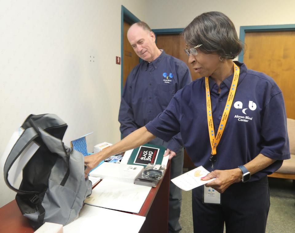 Akron Blind Center (inspired) Executive Director Scott Reisberg and member Thressa Mae Brown check over contents for backpacks to be distributed to visually challenged members on Thursday, Dec. 22, 2022, in Akron.