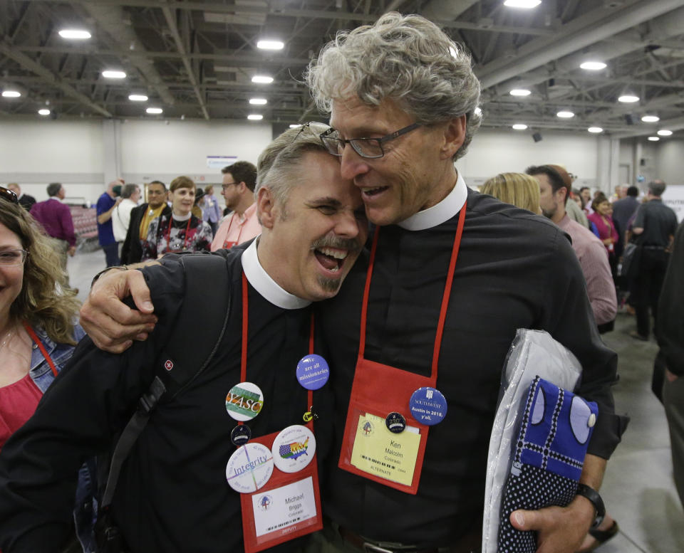 FILE - The Rev. Michael Briggs, left, and the Rev. Ken Malcolm, right, hug as they walk after Episcopalians overwhelmingly voted to allow religious weddings for same-sex couples Wednesday, July 1, 2015, in Salt Lake City. When the United Methodist Church removed anti-LGBTQ language from its official rules in recent days, it marked the end of a half-century of debates over LGBTQ inclusion in mainline Protestant denominations. The moves sparked joy from progressive delegates, but the UMC faces many of the same challenges as Lutheran, Presbyterian and Episcopal denominations that took similar routes, from schisms to friction with international churches to the long-term aging and shrinking of their memberships. (AP Photo/Rick Bowmer, File)