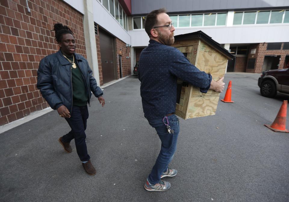 Scott Moore a careers and trades education teacher at Edison Tech, carries out a mobile food pantry box his students in the New York State Alternate Assessment program made for Devon Reynolds Sr. Reynolds is having 10 food cupboards made to put up around the city.