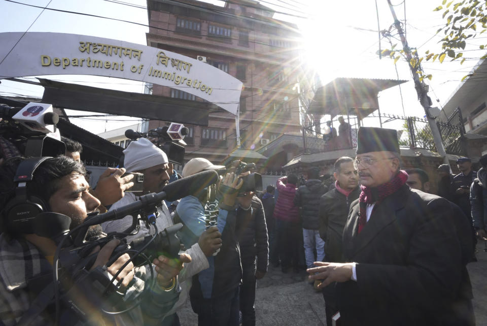 Charles Sobhraj's lawyer Gopal Siwakoti, right, talks to media outside immigration office, in Kathmandu, Nepal, Friday, Dec. 23, 2022. Confessed French serial killer Charles Sobhraj has been released from prison in Nepal after serving most of his sentence. Sobhraj was driven out of Central Jail in Kathmandu to the Department of Immigration under heavy guard Friday after the Supreme Court ordered him to be released because of poor health and good behavior. (AP Photo/Niranjan Shrestha)