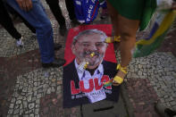 An image of former Brazilian President Luiz Inacio Lula da Silva, who is running for reelection, lays on the ground during a campaign rally for his rival, current President Jair Bolsonaro, in Juiz de Fora, Minas Gerais state, Brazil, Tuesday, Aug. 16, 2022. Bolsonaro formally began his campaign for re-election in this town where he was stabbed during his 2018 campaign. General elections are set for Oct. 2. (AP Photo/Silvia Izquierdo)