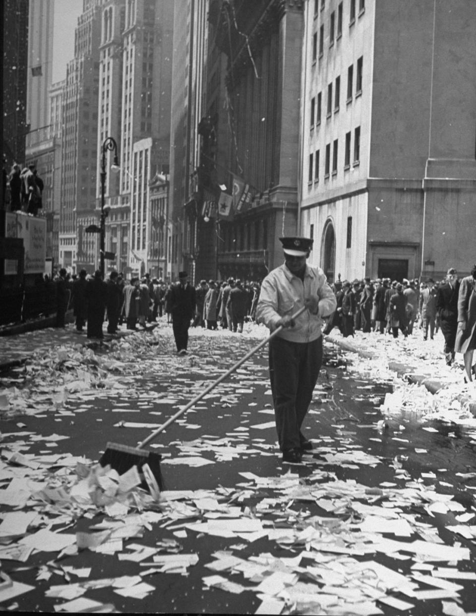 <p>A sanitation worker sweeps up a confetti-covered Times Square.</p>