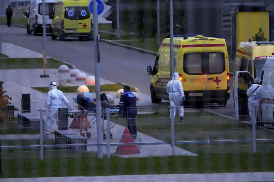 Medical workers carry a patient suspected of having coronavirus on a stretcher at a hospital in Kommunarka, outside Moscow, Russia, Saturday, Oct. 16, 2021. Russia's daily death toll from COVID-19 has exceeded 1000 for the first time as the country faces a sustained wave of rising infections. (AP Photo/Alexander Zemlianichenko)