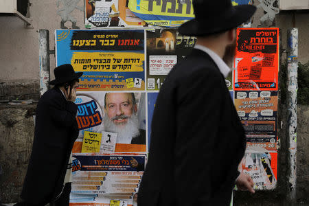 Ultra-Orthodox Jewish men walk past a campaign poster depicting ultra-Orthodox Jewish candidate in Jerusalem's mayoral election Yossi Daitsh, in Jerusalem October 18, 2018. REUTERS/Ammar Awad