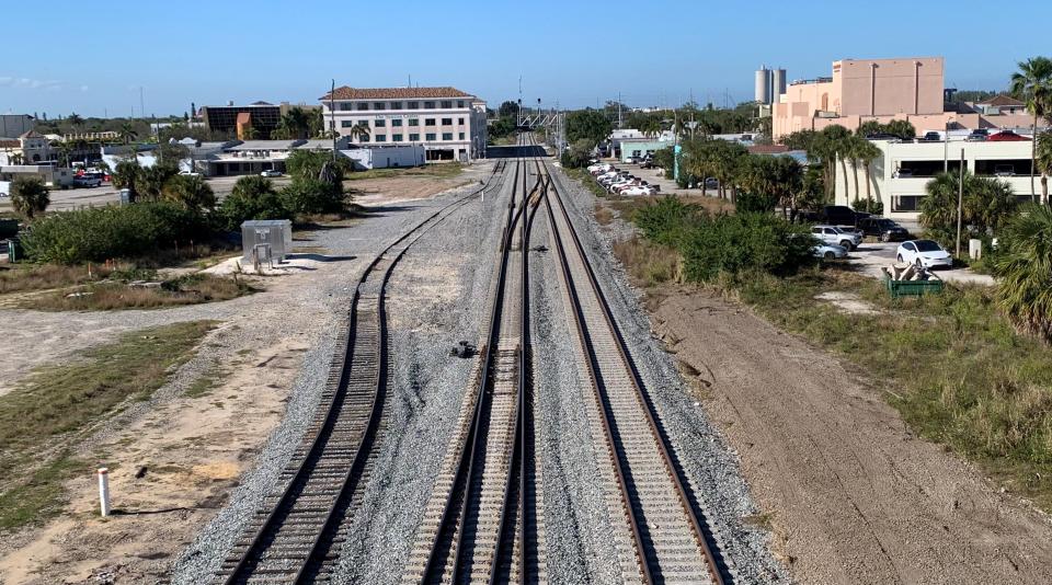 This view from the Citrus Avenue Bridge, looking north, shows a would-be Brightline station site (right) proposed by the city of Fort Pierce. The station would be built just west of the Sunrise Theatre and parking garage (white building, right), which would be expanded by more than 100 spaces. West (left) of the tracks,Florida East Coast Railway owns unused land on which it could build, potentially linking the sites. A second public parking garage is shown in the distance.