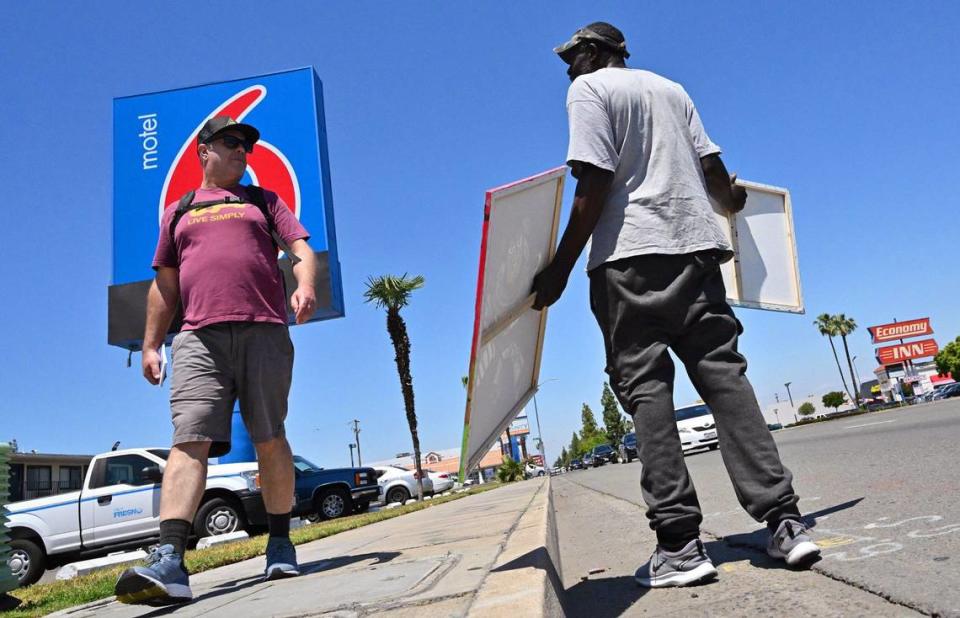 On his urban hike along Blackstone Avenue, Fresno Bee columnist Marek Warszawski, left, encounters Steven Smith who was selling his girlfriend’s art Wednesday, May 8, 2024 in Fresno. Smith said he expected to see more trees along Blackstone..