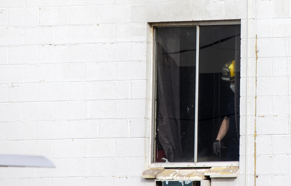Las Vegas firefighter stands by a window after a fatal fire at a three-story apartment complex early Saturday, Dec. 21, 2019 in Las Vegas. The fire was in first-floor unit of the Alpine Motel Apartments and its cause was under investigation, the department said. Authorities say multiple fatalities were reported and several were injured. (Steve Marcus/Las Vegas Sun via AP)