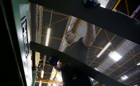 A worker at perforating company Bion feeds a piece of metal into a rolling machine at the factory in Reading, Britain September 22, 2016. REUTERS/Peter Nicholls