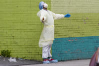 A medic of the Elmhurst Hospital Center medical team reacts after stepping outside of the emergency room, Saturday, April 4, 2020, in the Queens borough of New York. The new coronavirus causes mild or moderate symptoms for most people, but for some, especially older adults and people with existing health problems, it can cause more severe illness or death. (AP Photo/Mary Altaffer)