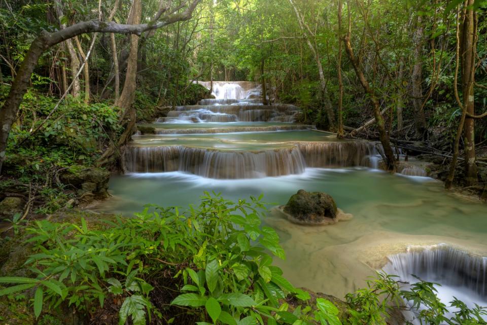 <p>Streams of sunlight peek through the tree covered Huai Mae Khamin Waterfall at Khuean Srinagarindra National Park, Thailand // Date unknown</p>