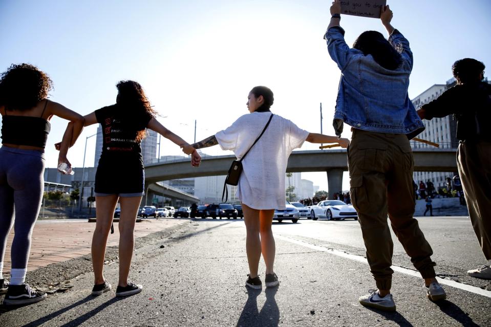 Protesters link arms to block a roadway