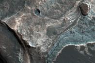 <p>Hier zeigt ein Bild des “Mars Reconnaissance Orbiter” die westliche Wand einer kleineren Mulde nahe der Coprates Catena, einer Art Tal, das aus mehreren kleinen Einbruchtälern besteht. Die umliegenden Wände zeigen mehrere Hänge. (Bild: NASA/JPL-Caltech/Univ. of Arizona) </p>