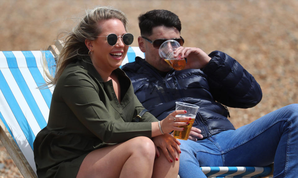 A young couple enjoy a beer in their deckchairs during the fine weather in Brighton, as people travel to parks and beaches with lockdown measures eased. (Photo by Gareth Fuller/PA Images via Getty Images)