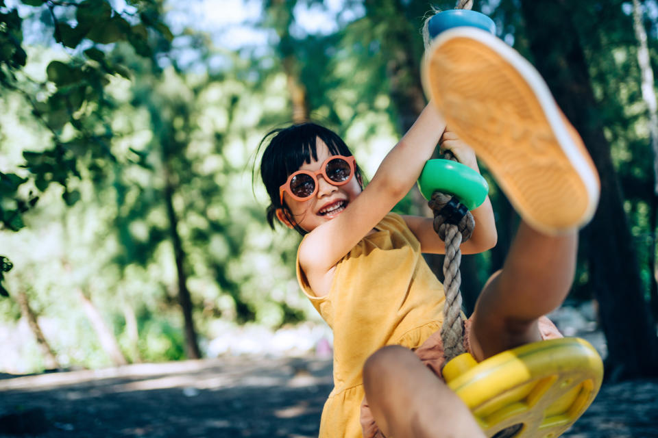 a kid playing on a swing set