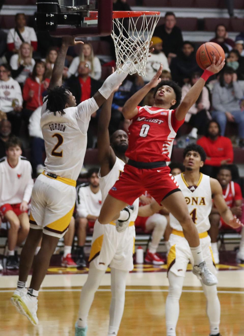 Marist's Jadin Collins (0) goes up for a shot in front of Iona's Greg Gordon (2) during NCAA basketball action at Hynes Center at Iona University in New Rochelle Nov. 29, 2023.