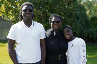 Joelle Wright-Terry poses with her sons Joshua and Micah in Clinton Township, Mich., Thursday, Sept. 17, 2020. As the U.S. surpasses its 200,000th pandemic death, the losses are taking shape in heartbreaking ways. “My dad was my best friend,” Joshua says about Marshall Terry III, who died in April from symptoms of coronavirus. “My goal is to make him proud while he watches from heaven.” (AP Photo/Paul Sancya)