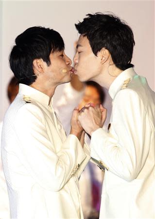 South Korean film director Kim Jho Gwang-soo (L) kisses his partner Kim Seung-hwan during their wedding ceremony in central Seoul September 7, 2013. Kim Jho Gwang-soo married his long-term partner on Saturday in this conservative Asian country where homosexuality is still taboo and gays have been subjected to hate crimes. REUTERS/Lee Jae-Won